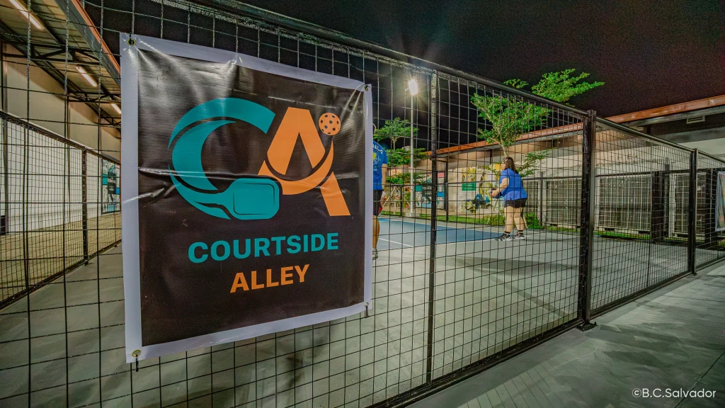 Courtside Alley banner on the court fence at night